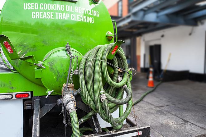 a grease trap pumping service in action at a commercial building in Breesport, NY